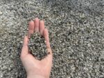 Серая гранитная крошка фракции 2–5 мм в ладони